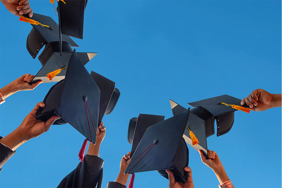 The students holding a shot of graduation cap by their hand in a bright sky during ceremony success graduates at the University, Concept of Successful Education in Hight School,Congratulated Degree