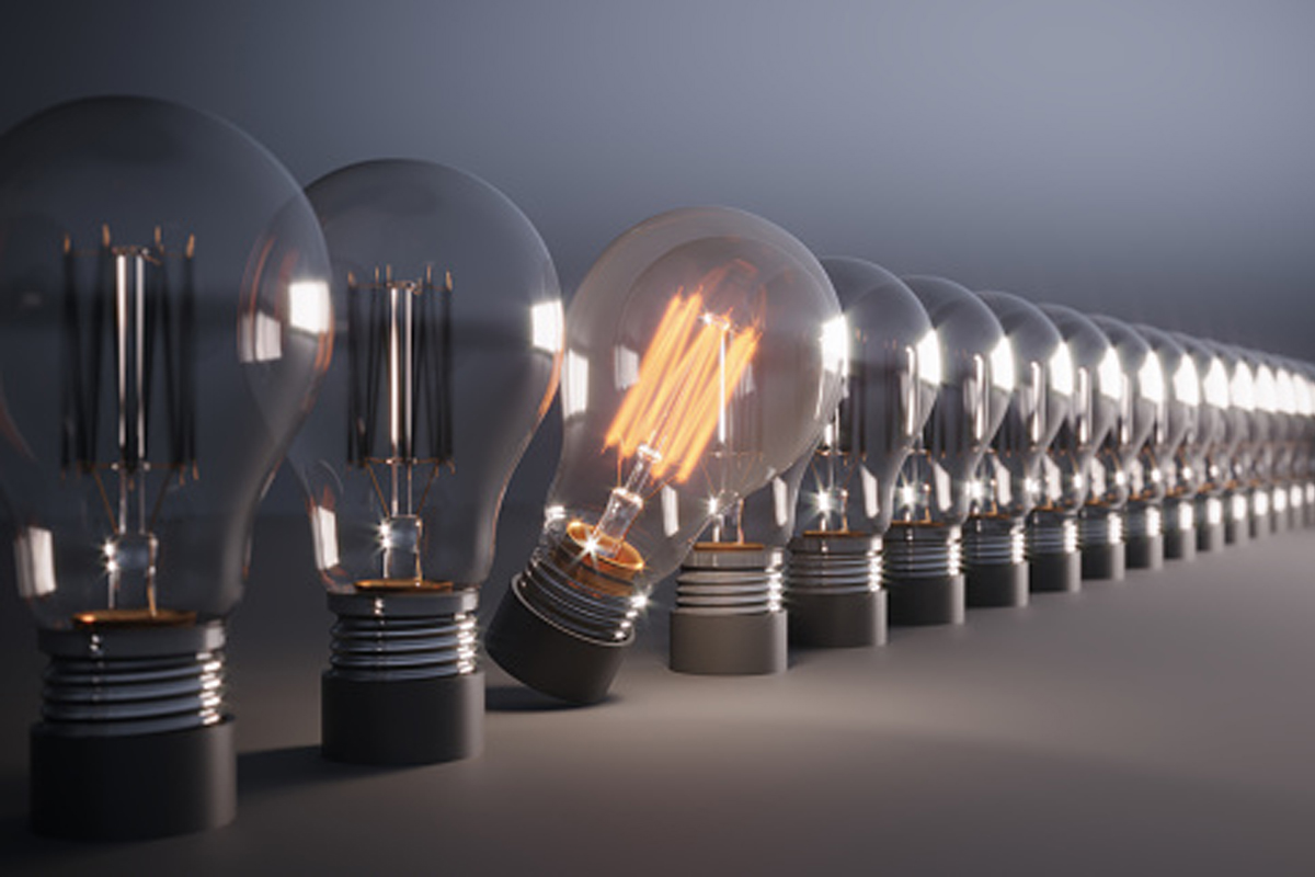Glowing Light Bulb between the others. Can be used leadership, innovation and individuality concepts.  (3d render)