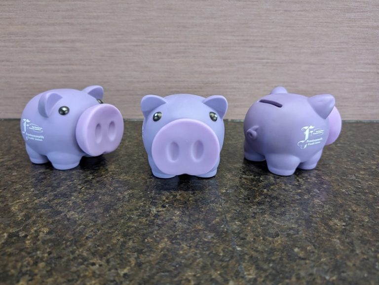 Branded piggy banks used in a school-based child savings account program to encourage students to save between deposit days.